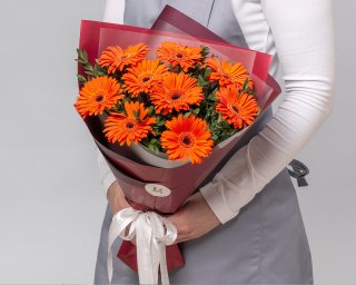 Букет из 9 оранжевых мини гербер в стильной упаковке с зеленью  small - 3
